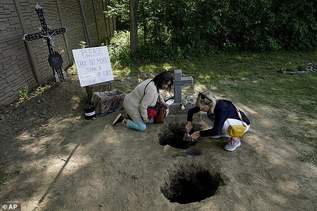 Pictured: People collect soil from the grave of Sister Wilhelmina Lancaster at the Benedictine Abbey of Mary, Queen of the Apostles, Sunday, May 28, 2023