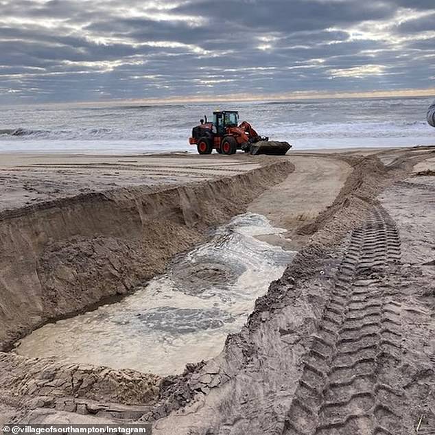 Workers can be seen processing the polluted water after it has been dumped over the sand