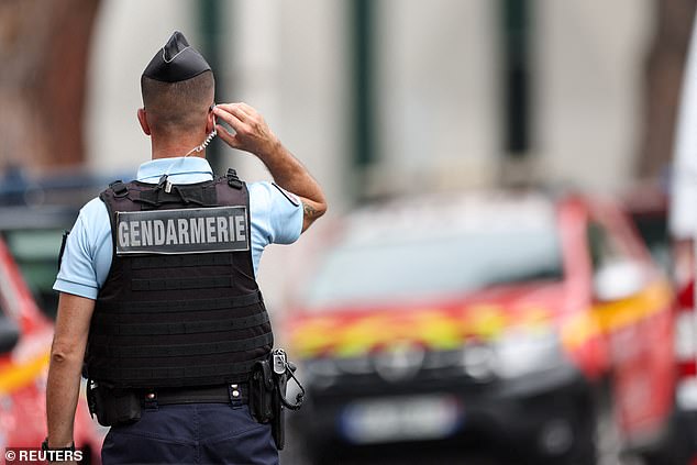 A gendarmerie officer stands guard after cars were set on fire in front of the city's synagogue,