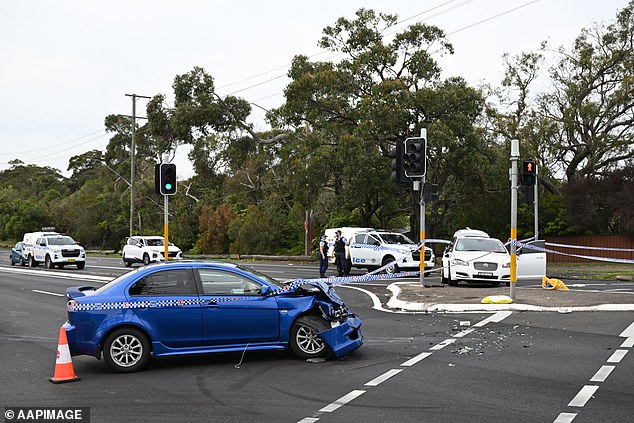 Police are investigating the incident, which left several passengers taken to hospital with stab wounds (pictured is the crumpled blue Mitsubishi sedan)