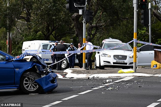 Police are pictured at the scene of an alleged stabbing incident, where a driver is accused of stabbing three people after crashing his car