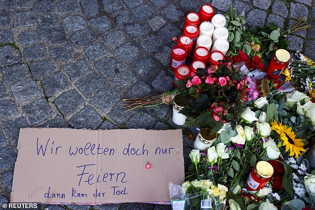 A sign with the text: "We just wanted to party, but then death came" is placed next to flowers and candles