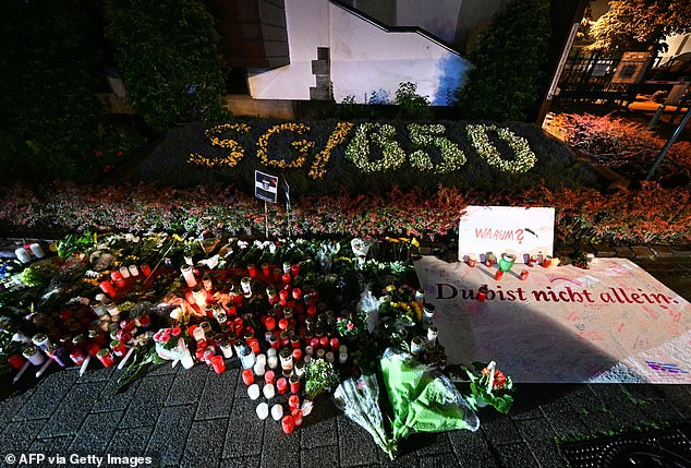 Candles and flowers and the inscription "Why? You are not alone" are pictured on August 24, 2024 near the area where three people were killed and several injured