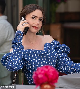 Polka dots are a big part of part 2 fashion. A photo of Emily enjoying a drink at an outdoor cafe reveals a blue and white off-the-shoulder blouse with a sweetheart neckline