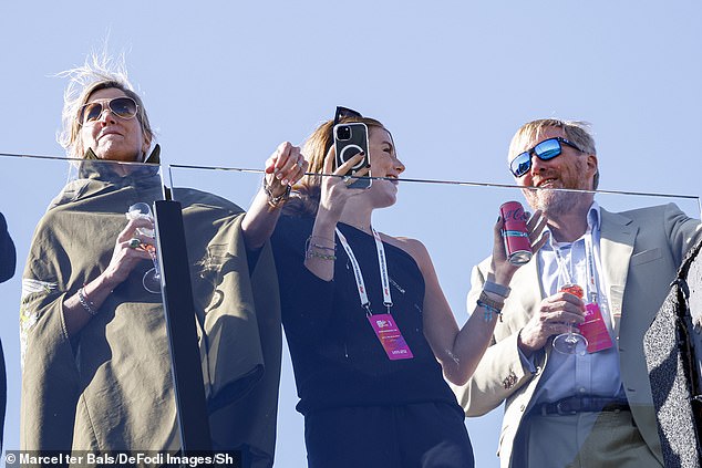 Alexia seemed completely absorbed in the race, filming the drivers racing around the track on her smartphone while chatting to her father