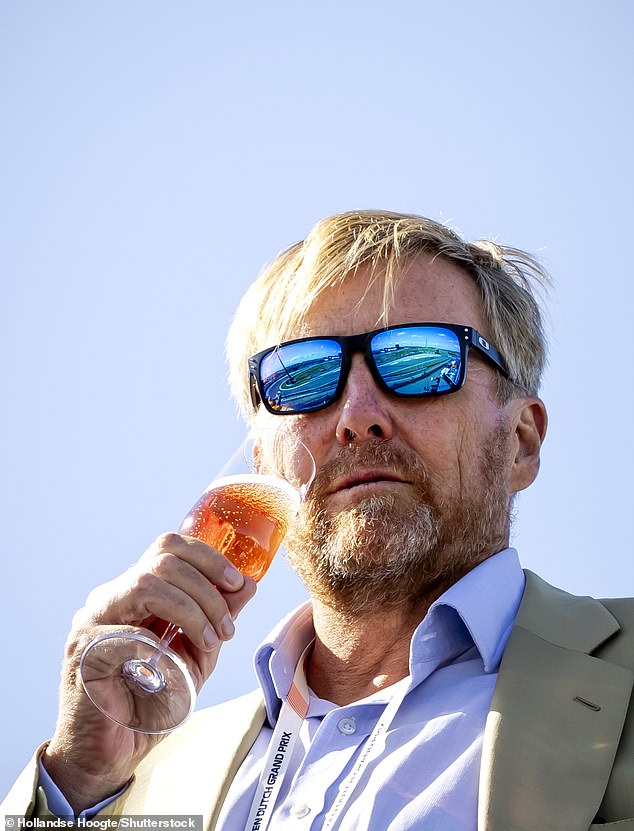 In one photo, the King was seen enjoying a glass of bubbly as he watched the drivers race around the circuit