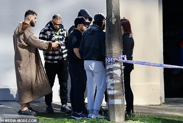 Pictured: Friends and family comfort each other after the shooting