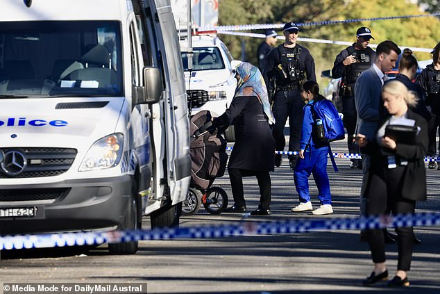 Witnesses reported hearing at least eight shots, with the victim reportedly being attacked in an apartment complex garage (pictured: police at the scene)