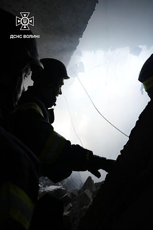 Rescue workers in a building in Lutsk after it was hit by a Russian drone strike