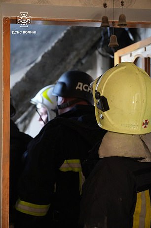 Rescue workers in a building in Lutsk after it was hit by a Russian drone strike