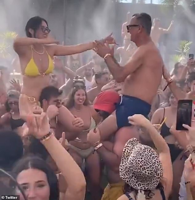 Noa sits on the shoulders of a friend while dancing with her father Yaakov, who is also leaning on someone's shoulders