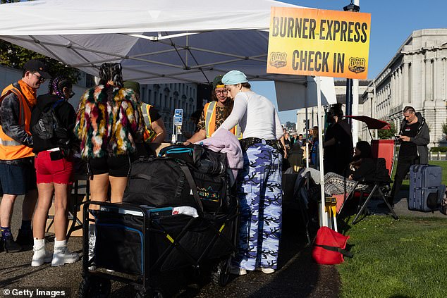 Festival-goers check in for buses to Burning Man at Civic Center Plaza on Sunday