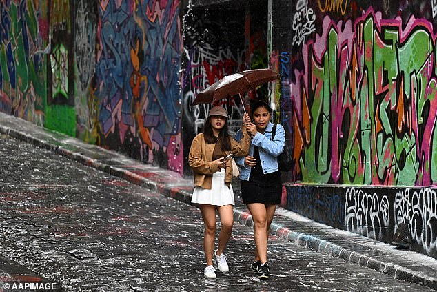 Victoria is likely to see showers and damaging wind gusts - especially on Wednesday, when winds could blow up to 100km offshore (pictured of people walking in Melbourne)