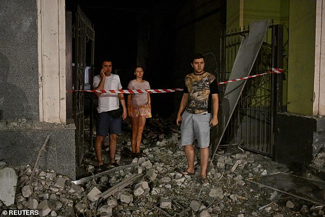 Local residents stand at the site of a Russian missile attack, during the Russian attack on Ukraine, in Kryvyi Rih