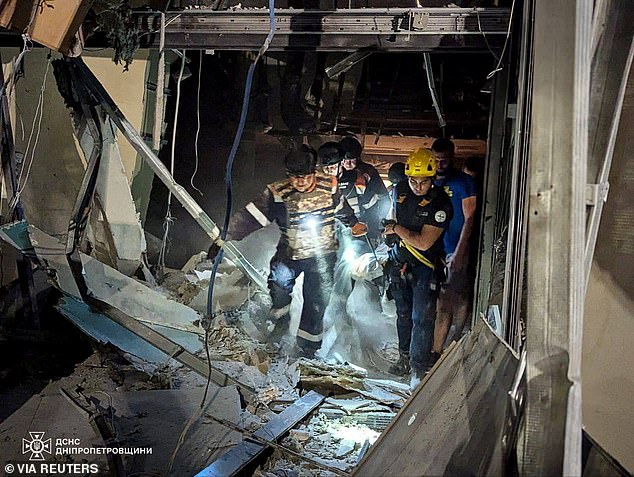 Rescue workers carry a victim at the scene of a Russian missile attack in Kryvyi Rih