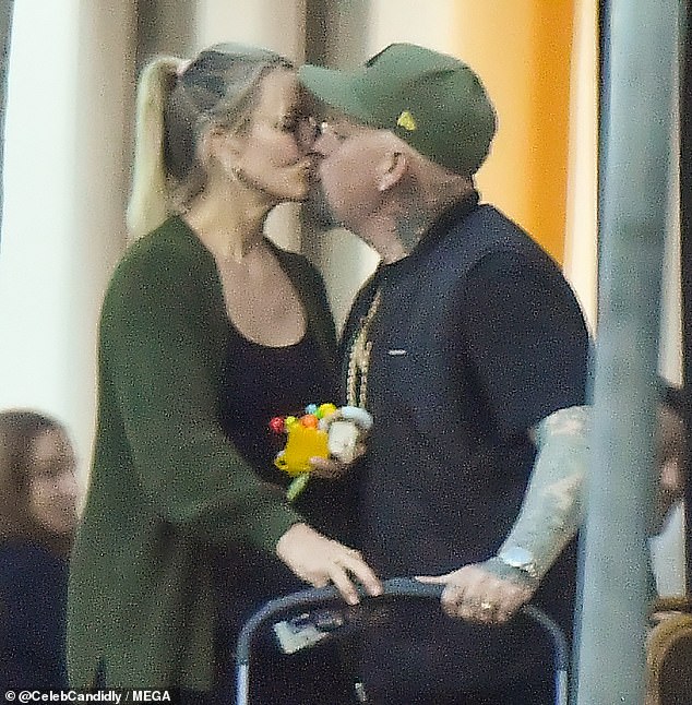 The couple were spotted standing next to a stroller outside a food court and shared a sweet kiss