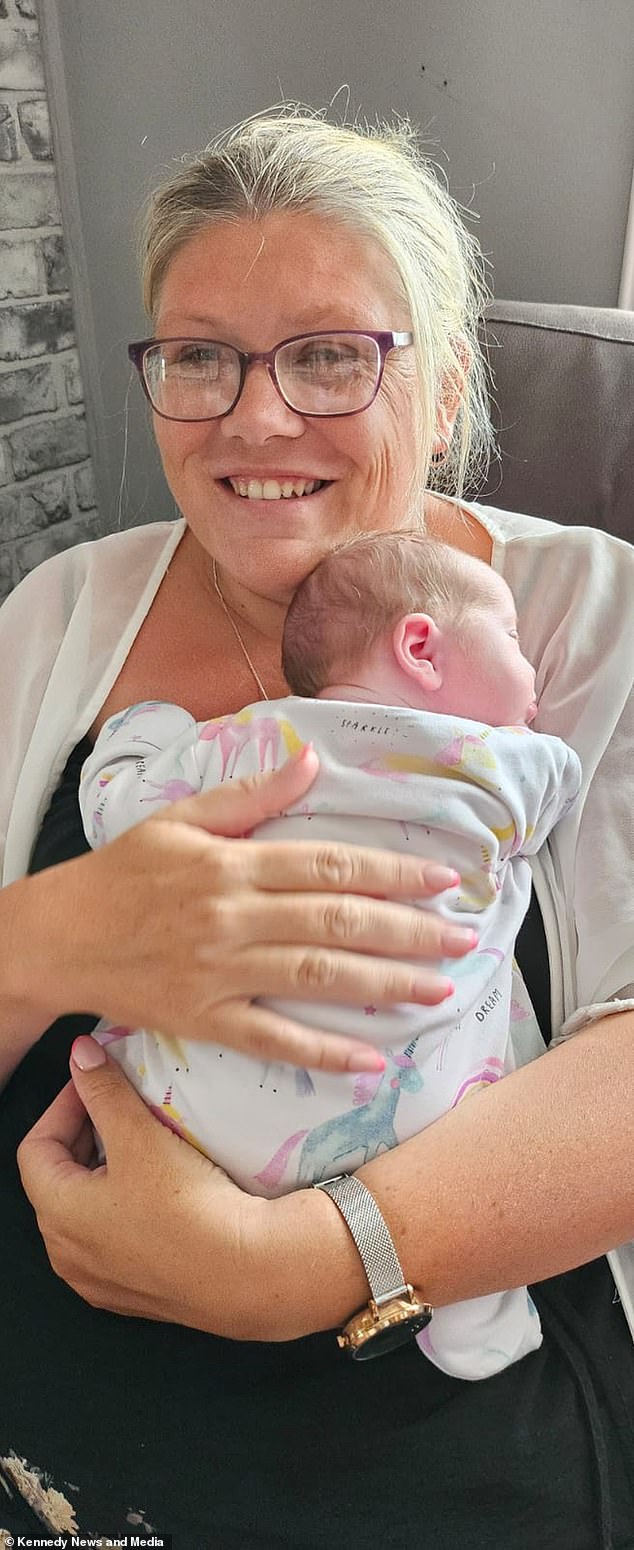 Zoe is photographed holding her newborn Hayley, who surprised the family on August 1