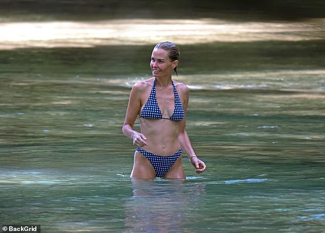 The 37-year-old model showed off plenty of skin in a scantily floral blue bikini during the outing, where she was joined by her 48-year-old husband Sam Worthington and their children.