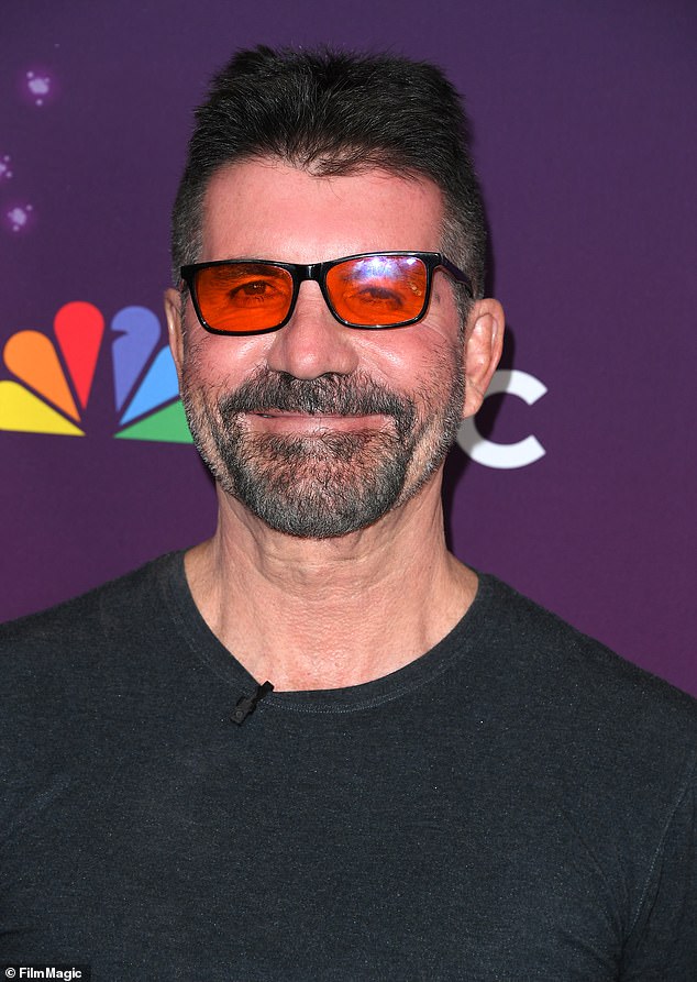 While posing on the red carpet, Simon wore red glasses that he uses to prevent migraines