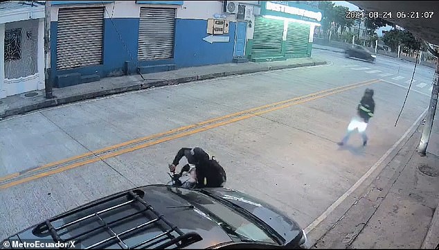 A robbery suspect attempted to restart his motorcycle as his accomplice approached him, moments before a Good Samaritan crashed his vehicle into the motorcycle for a second time, knocking the assailant to the ground before he and his accomplice fled Saturday in Guayaquil, Ecuador.