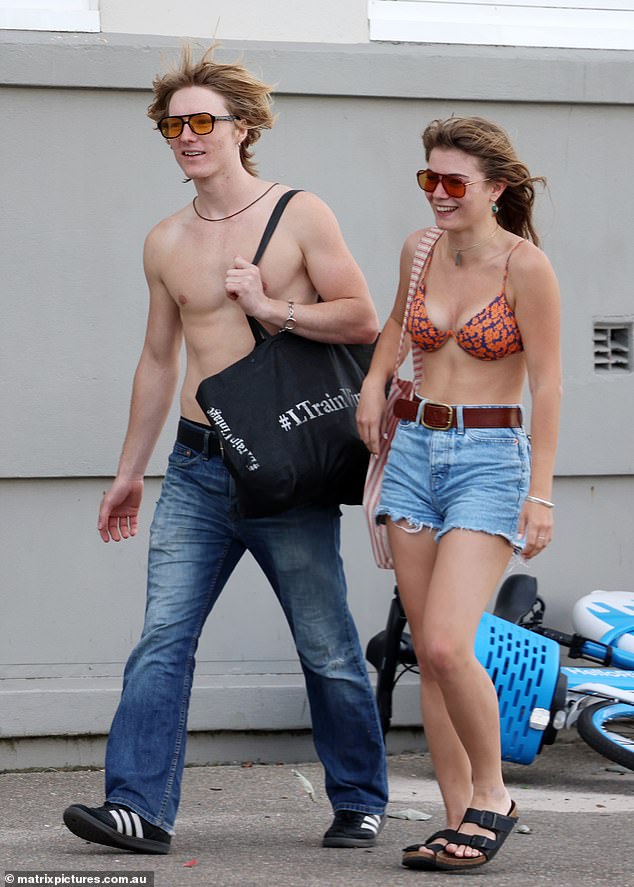 In keeping with the old school look, Mia teamed her swimsuit with a pair of high waisted denim shorts, a tan belt and red sunglasses