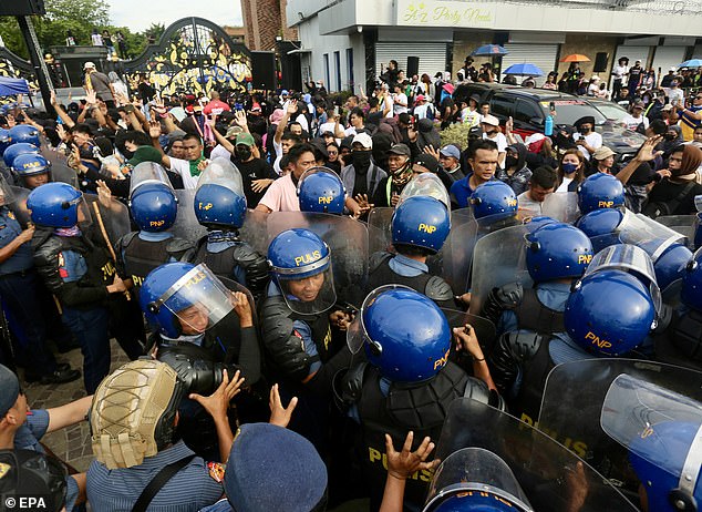 Riot police block supporters of religious leader Apollo Quiboloy during a protest rally outside the Kingdom of Jesus Christ (KOJC) complex in Davao on August 26