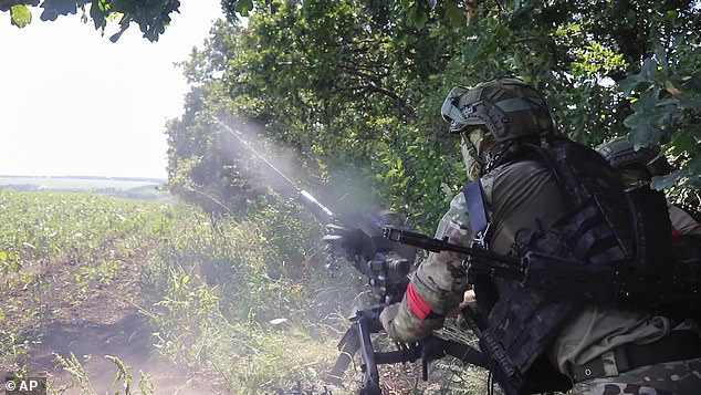 Russian soldiers fire an AGS-17 automatic grenade launcher at Ukrainian positions at an unknown location in Russia's Kursk region