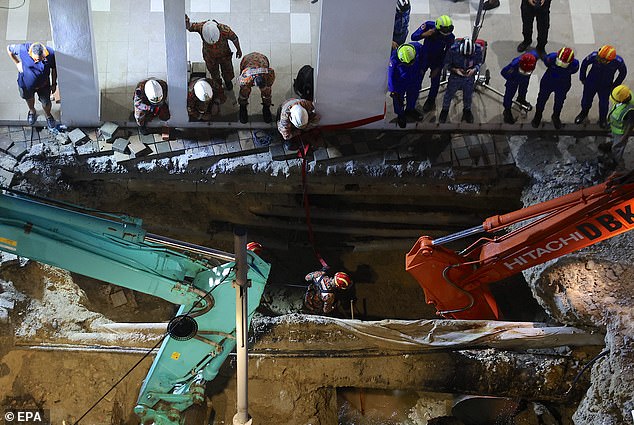 Rescue efforts continue into the night as fire rescue teams inspect the sinkhole