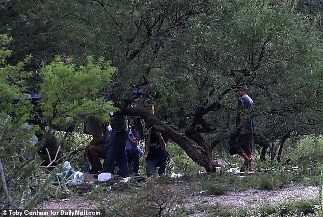 A group of migrants and smugglers have set up shop just metres from a gap in the border wall