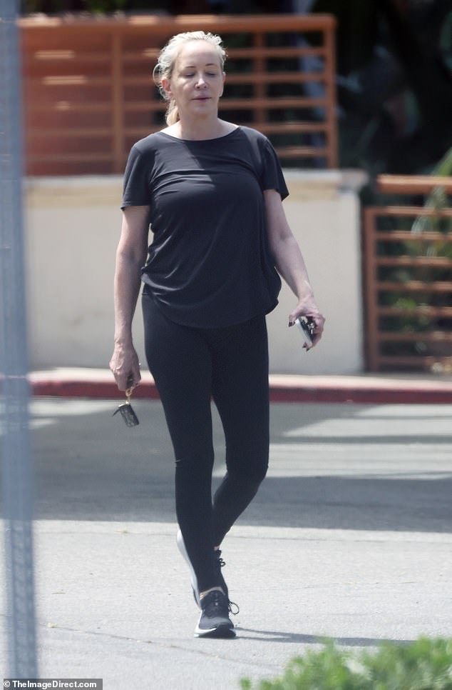 Shannon - with her phone and keys in her hand - wore a baggy black T-shirt, matching leggings and sneakers for her errands