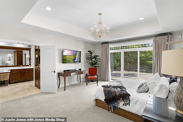 The master bedroom is complete with its own hallway and a glittering chandelier