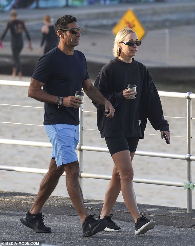 The couple were seen enjoying hot drinks as they walked along the beach together on a sunny morning