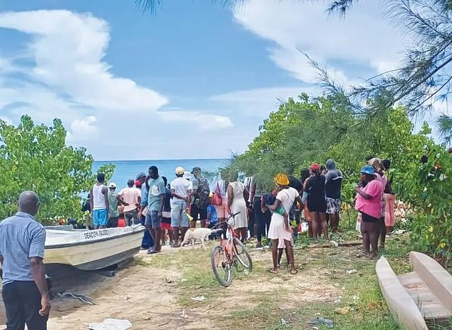 Locals from the town of Falmouth gathered on the beach as the body was recovered