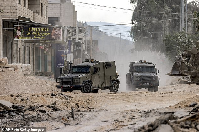 Israeli armored vehicles drive on a road during a military operation in Tulkarm in the northern occupied West Bank