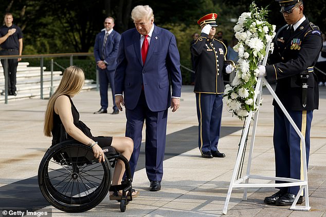 Republican presidential candidate, former US President Donald Trump lays a wreath next to Marine Cpl. Kelsee Lainhart (Ret.), who was injured in the Abbey Gate bombing