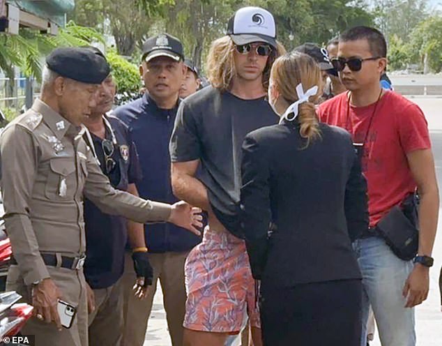 A handout photo provided by the Royal Thai Police shows a Spanish chef, a murder suspect Daniel Jeronimo Sancho Bronchalo, (center) being escorted by Thai police officers during a crime reconstruction at a crime scene on Koh Phangan island, southern Thailand, August 7, 2023