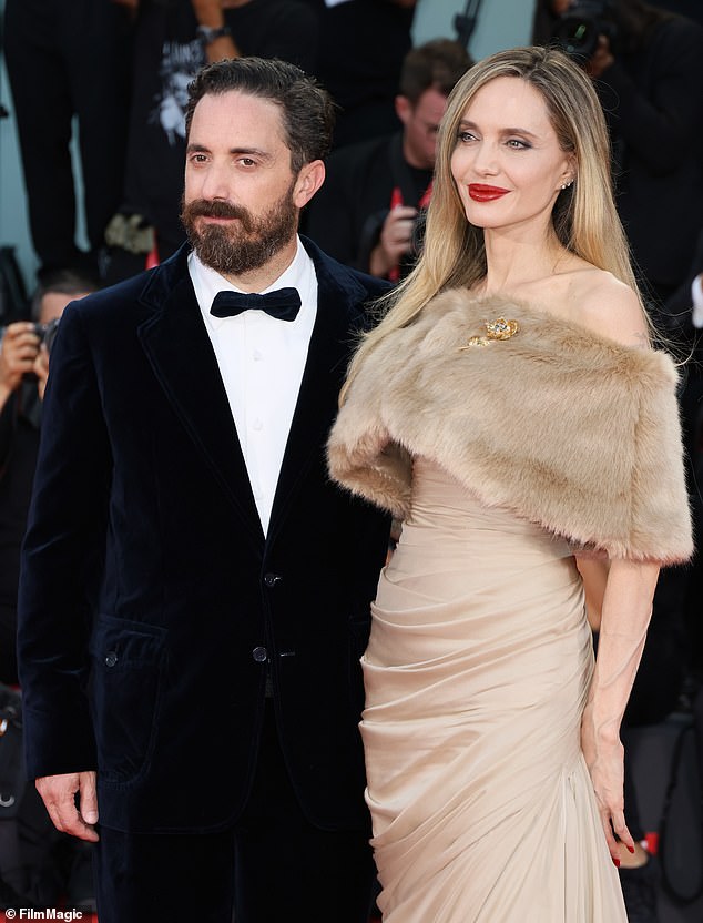 She was photographed being escorted down the stairs by Chilean filmmaker Pablo Larraín, 48, as the crowd continued to applaud her; seen with Pablo on the red carpet