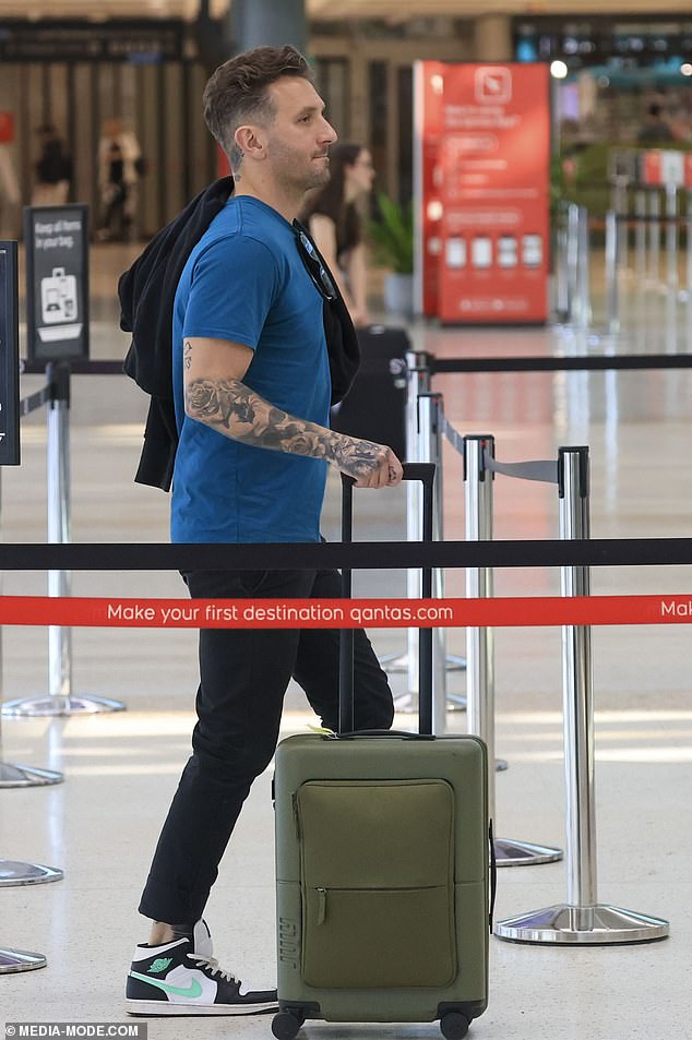 Tommy wore a blue t-shirt that showed off his many arm tattoos, paired with black jeans. He completed his look with a pair of Nike Air Jordan 1's in black, white and teal