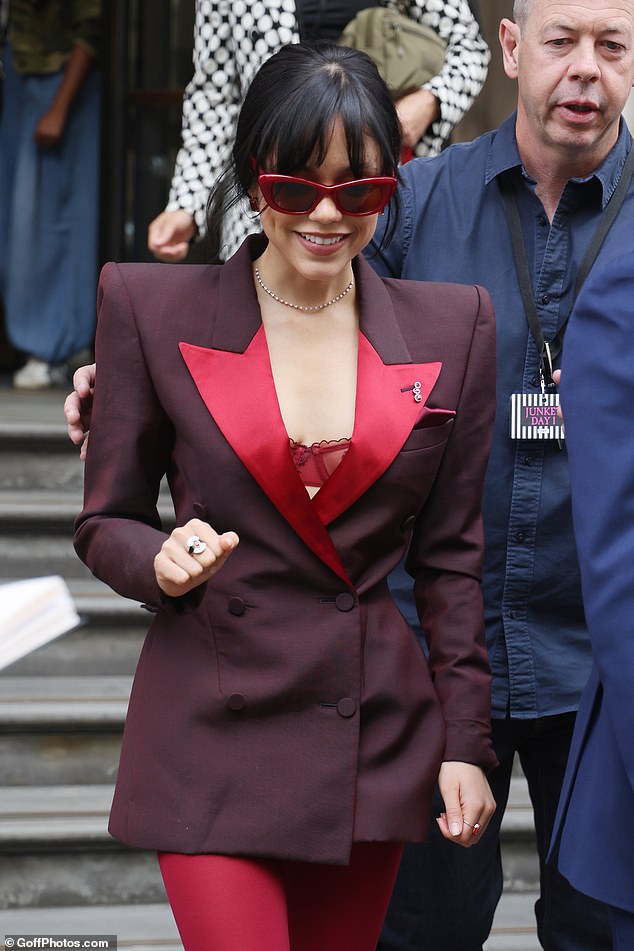 The 21-year-old actress, who plays Astrid Deetz in the film, showed off her quirky sense of style as she attended the photo shoot in a plunging maroon blazer that showed off her scarlet bra