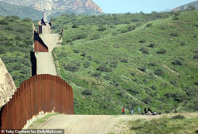 Migrants wait for a Border Patrol ride in remote areas of the southern Arizona desert