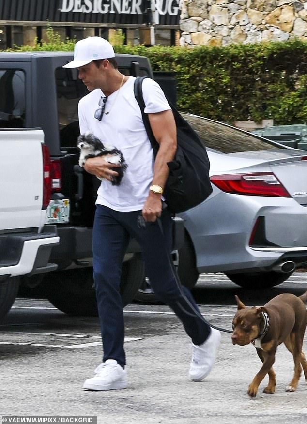 Brady showed off his muscular arms while carrying Fluffy, the dog he and ex-wife Gisele Bundchen rescued in 2016