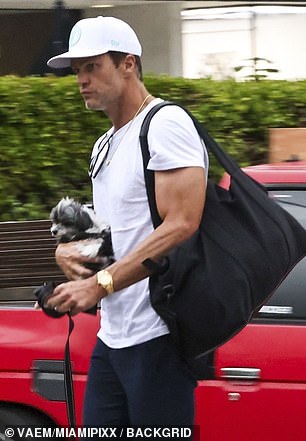 Brady carries dog Fluffy to his car