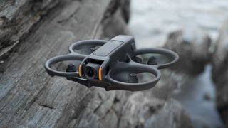 DJI Avata 2 FPV drone in flight over rocky beach