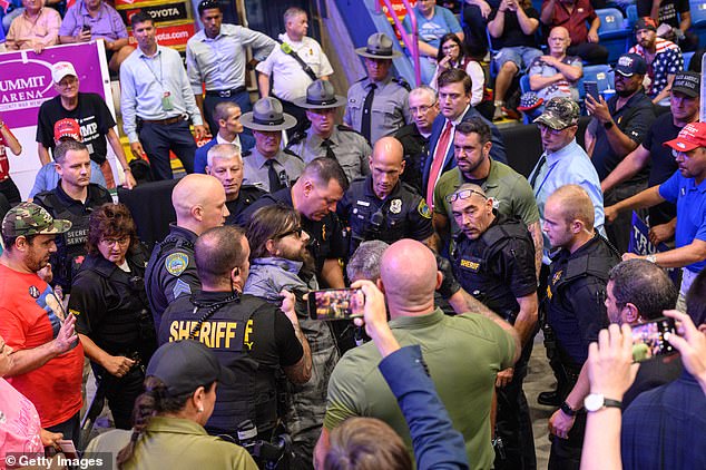 Officials managed to pull him off the metal fence as the crowd continued to chant