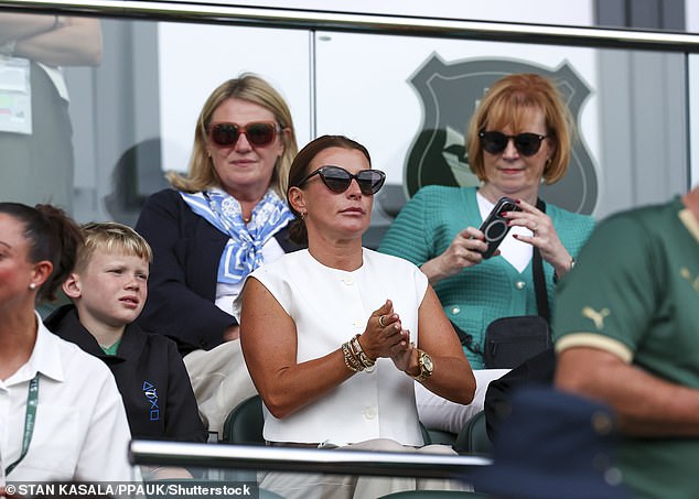 The 38-year-old TV personality looked chic in a white cap-sleeved shirt and matching trousers as she sat in the director's box at Home Park stadium with three of her sons.