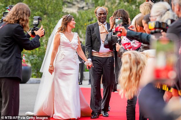 The happy couple hold hands as they walk the red carpet in front of the press and crowd of fans