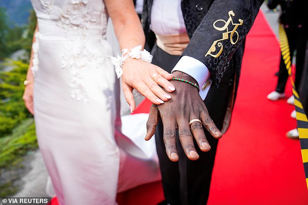 They show off their wedding rings and intricate details on both outfits