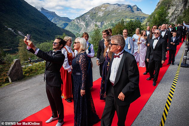 More guests walk the red carpet and take selfies with the beautiful backdrop