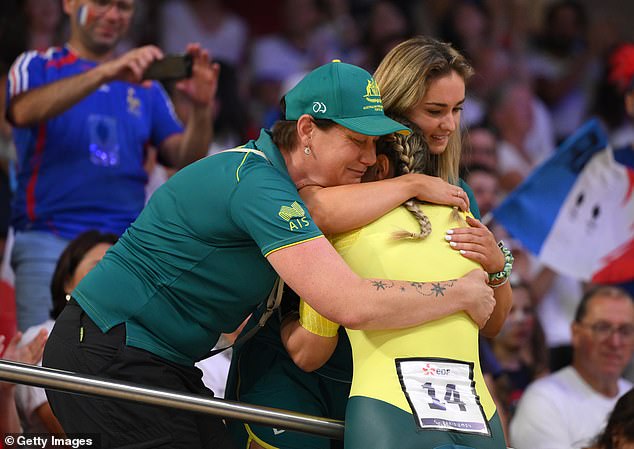 Reid celebrates her emotional victory on the track with her team at the Paris Games