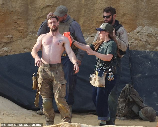 Taylor-Johnson gets washed up by the makeup crew during filming on set